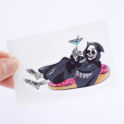 Grim Reaper on a Pool Floaty Sticker (Small) | Holding with fingers | Ash Robertson Design